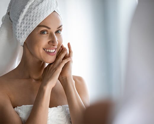 Kobieta po kąpieli patrzy w lustro